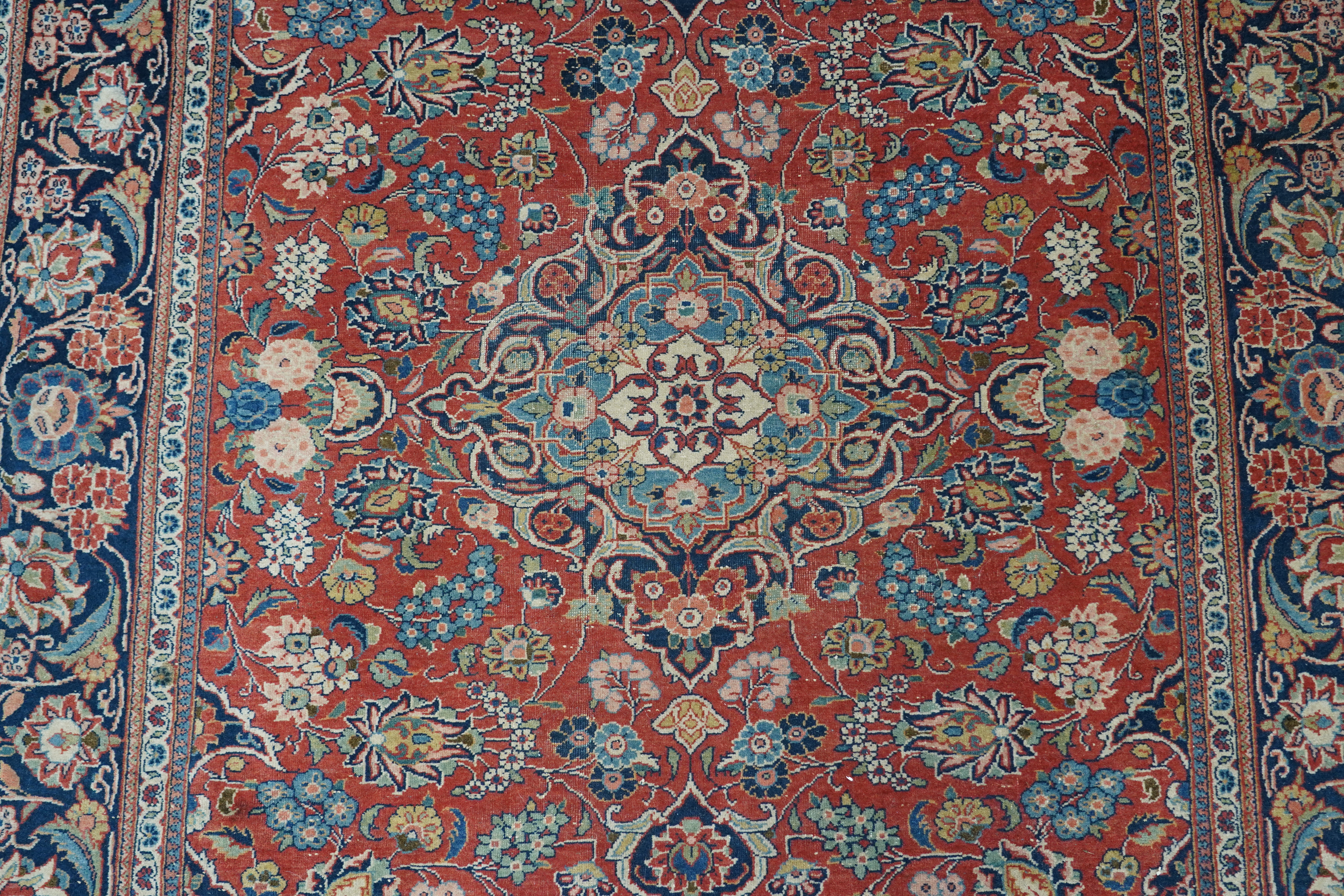 A pair of antique Tabriz brick red ground rugs, 200 x 136cm. Condition - fair